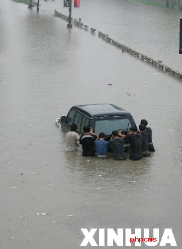 8月3日，几名济南市民正在水中推车。